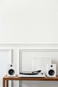 Zgrabna, drewniana komoda o minimalistycznym designie, z białym gramfonem.